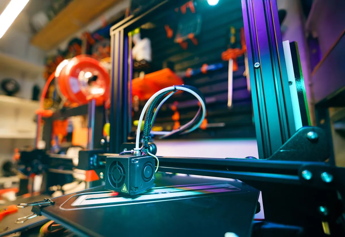 Close-up of a 3D printer hotend and toolhead in a home workshop setup